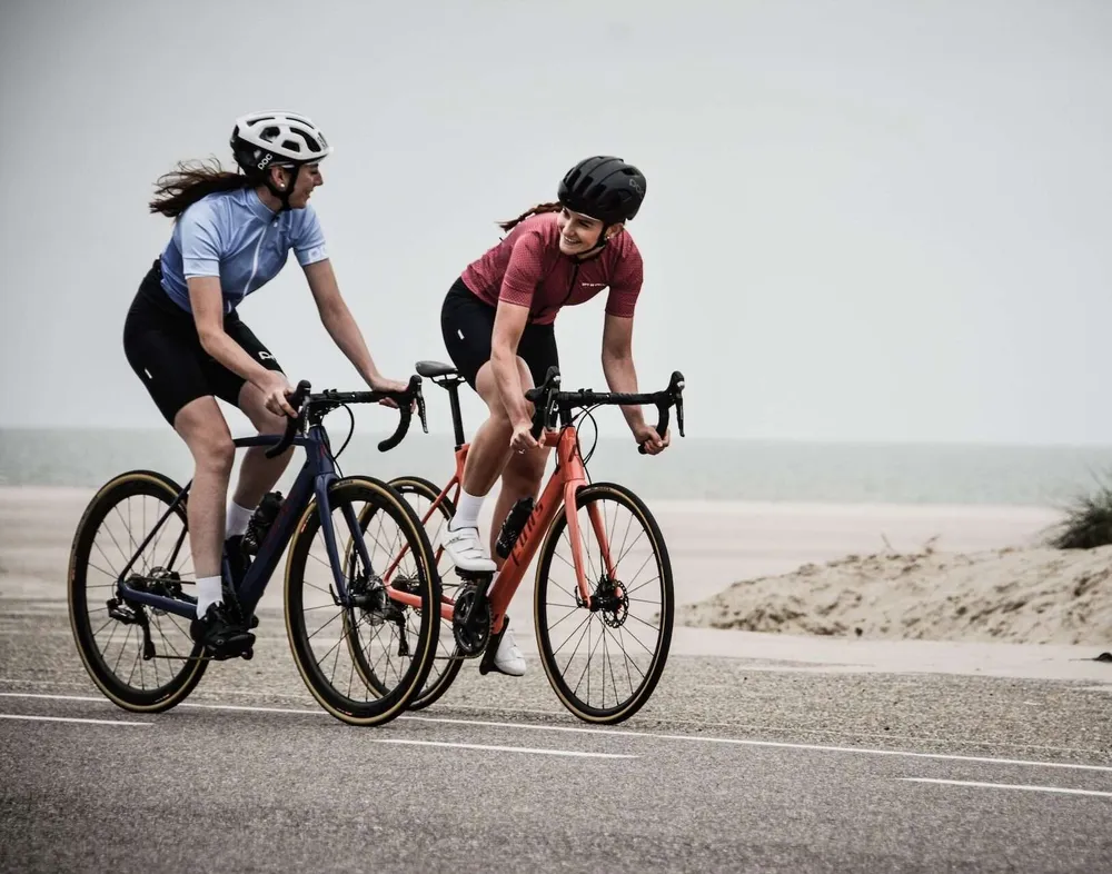 Deux cyclistes sur une route en bord de mer