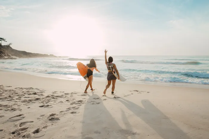 Amies sautant sur la plage